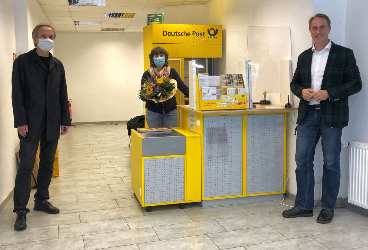 Stadtbürgermeister Falko Hönisch überreicht einer Mitarbeiterin zur Eröffnung der Postfiliale in St. Goar Blumen.