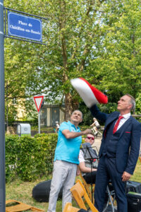 Beschreibung: Die beiden Bürgermeister, Michel Marie, Châtillon-en-Bazois, Falko Hönisch, Sankt Goar, (v.l.n.r.) enthüllen gemeinsam das Schild mit der neuen Platzbebennung . © Reinhardt A. Hardtke 