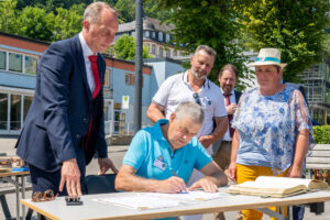 Beschreibung: Unterzeichnung der neuen Partnerschaftsurkunden ; am Tisch : Michel Marie, Bürgermeister Châtillon-en-Bazois, stehend links daneben : Falko Hönisch ; im Hintergrund : Jean-Pierre Freguin, Peter Unkel (v.l.n.r.); stehend rechts : Stéphanie Vin. © Reinhardt A. Hardtke 